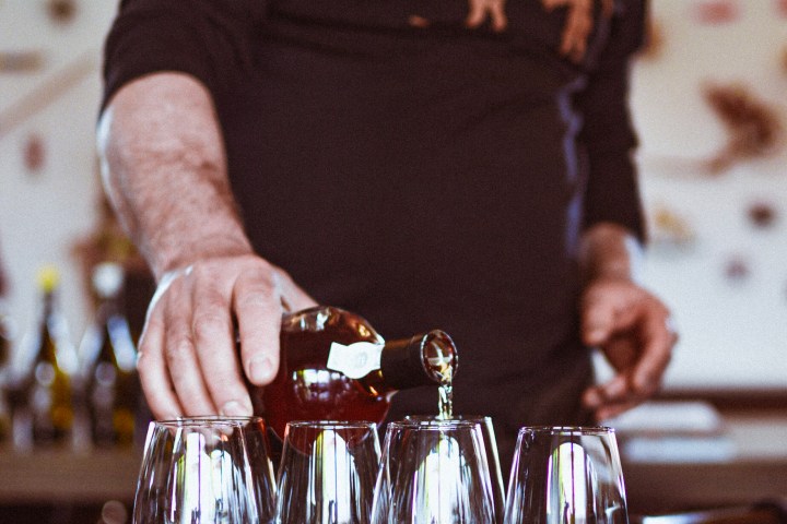 a man sitting at a table with wine glasses